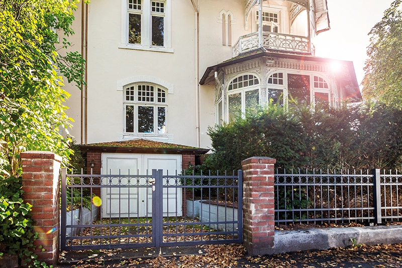 Ein schmiedeeisernes Einfahrtstor und Zaun vor einer Hamburger Villa