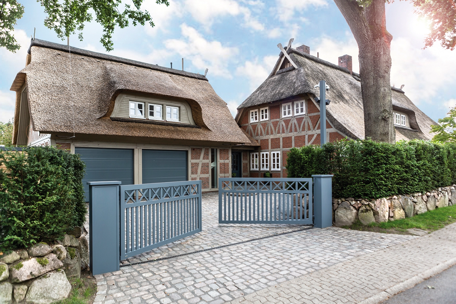 Einfahrtstor aus Aluminium im Landhausstil vor Fachwerkhaus