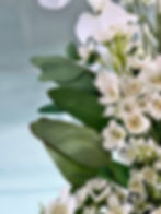 Artificial white wax flower stems with greenery