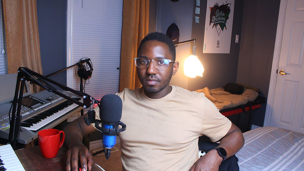 A content creator sits in a cozy home studio, surrounded by a keyboard, microphone, and a warm red mug, ready for recording.