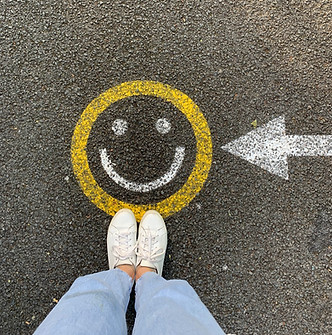 yellow and white smiley face painted on asphalt