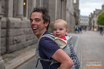 Baby carried in a buckle carrier