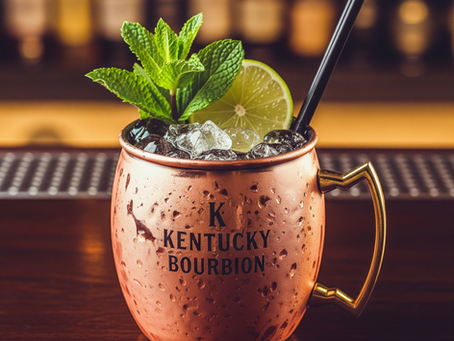 Ein Kentucky Mule Cocktail in einem Kupferbecher, gefüllt mit Eis, garniert mit Minze und einer Limettenspalte.