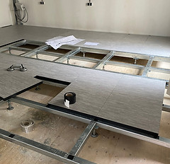 Constructievloer in een kantoor, geïnstalleerd voor flexibel kabelbeheer en een moderne, efficiënte werkplekomgeving.