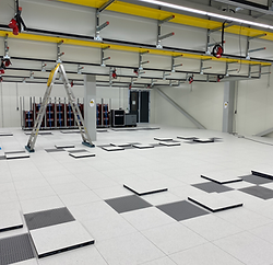 Constructievloer in een datacenter, geïnstalleerd voor optimaal kabelbeheer, luchtstroom en ondersteuning van zware apparatuur.