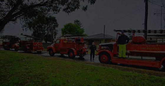 Museum of Fire volunteers standing infront of heritage fire engines on parade