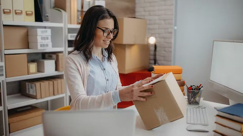 Mulher embalando pacote para entrega de e-commerce
