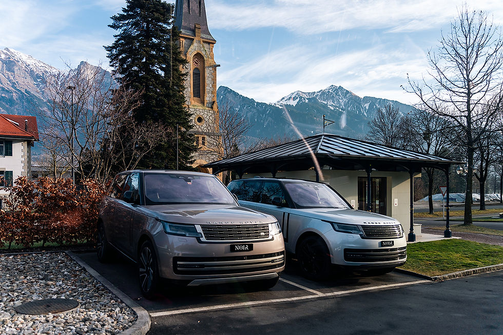 Range Rover parked near alpine mountains and church tower prepared for winter road conditions in Davos.