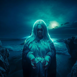 Frau als Tod kostümiert vor einem Meer