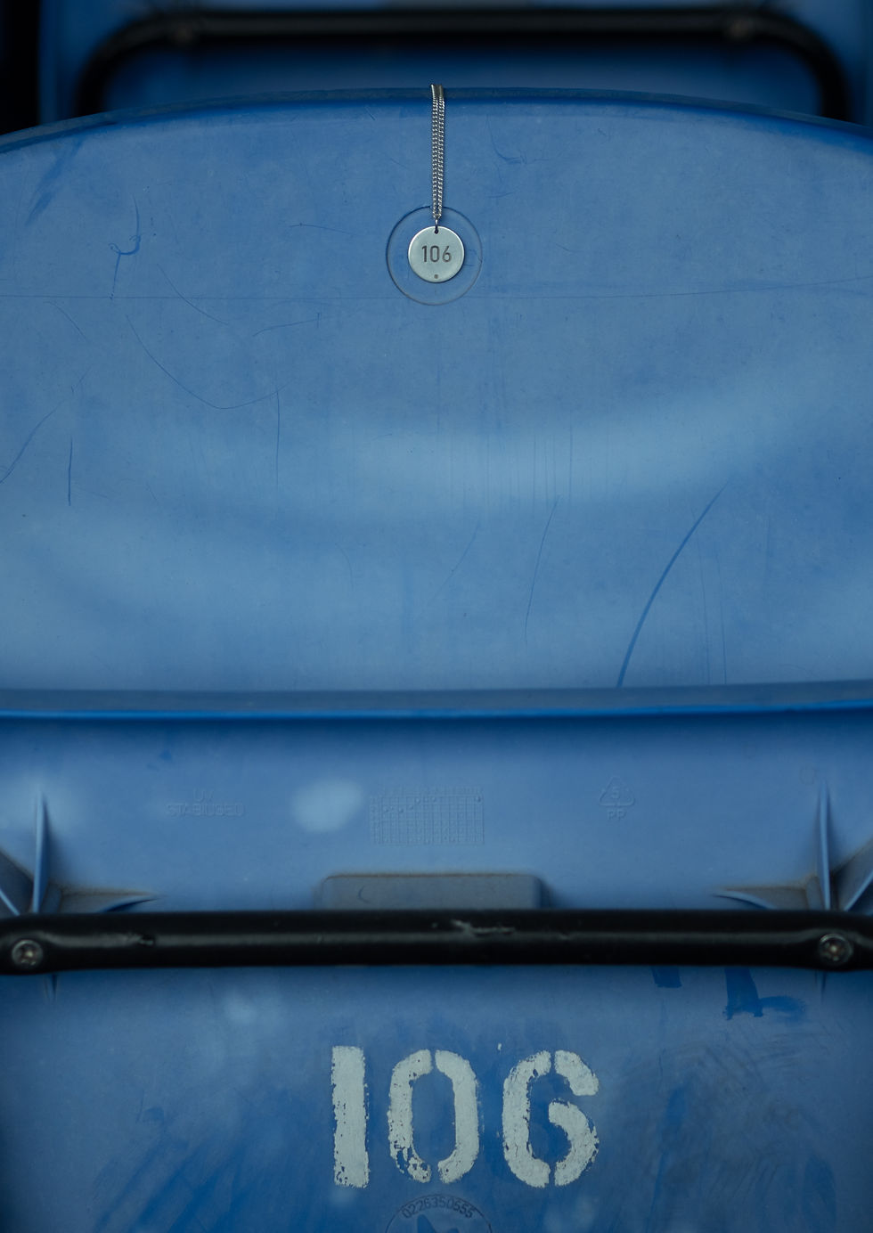 Thumbnail: Engraved 106 seat number dog tag jewelry pendant made of sterling silver laying on an Everton season ticket holder's seat at