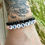 Thumbnail: Beaded bracelet with round pink glass beads. The word sister in white and black letter beads with red heart beads on either side.