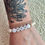 Thumbnail: Beaded bracelet with round cream colored glass beads. The word mom in white and gold letter beads with two gold hearts on either side.