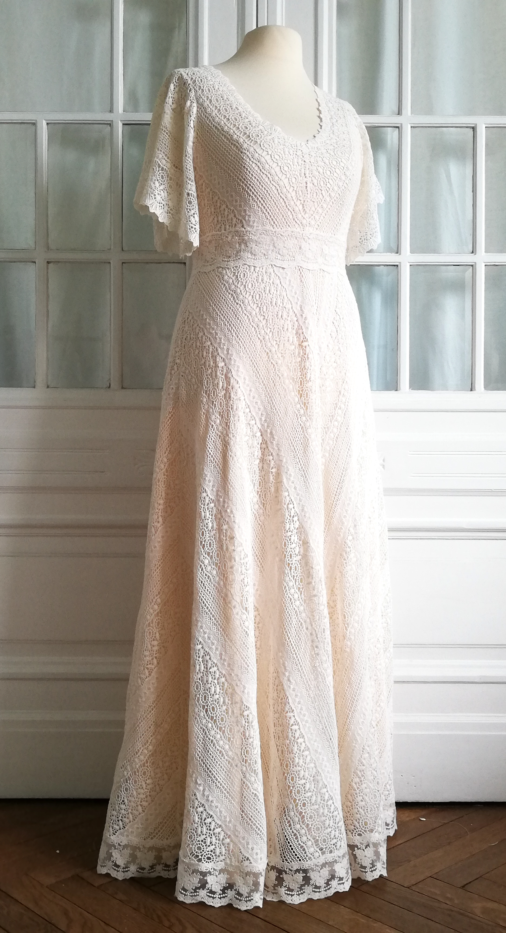 2-lagiges Brautkleid mit Überkleid aus weicher, grafisch gestickter Baumwollspitze. Weite, halblange Ärmel und Taillenband aus Spitze