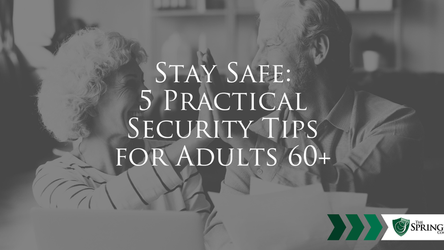 Elderly couple smiling and high-fiving in a cozy living room. They hold papers, with a laptop in front. The mood is joyful.