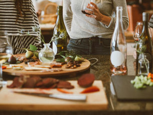 group of friends around a table with food and wine