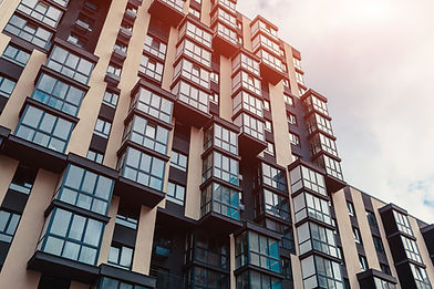 A apartment block looking up towards the sky.