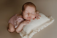 Photo de bébé posé sur coussin texturé prise lors d'une séance naissance en studio à Raismes.
