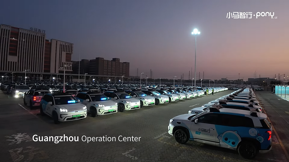 Rows of white cars with blue logos are parked under bright lights at dusk. A building and "Guangzhou Operation Center" text are visible.