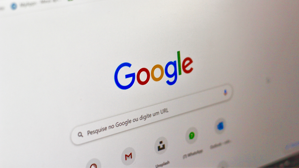 Google search page on a computer screen. The colorful Google logo is above the search bar with icons below, in a simple interface.