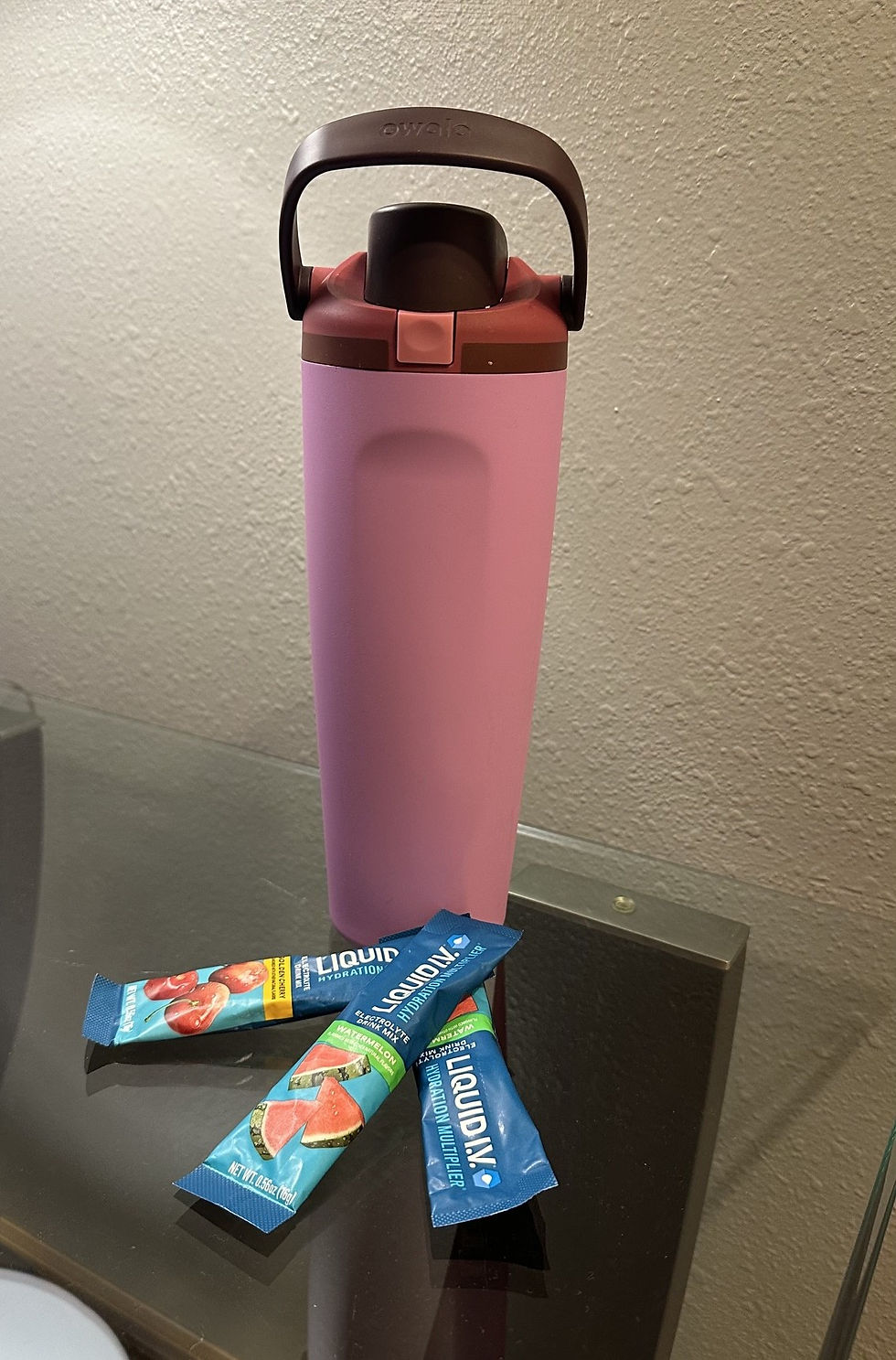 Large water bottle next to Liquid IV sugar free electrolyte packets for GLP1 hydration and kidney protection