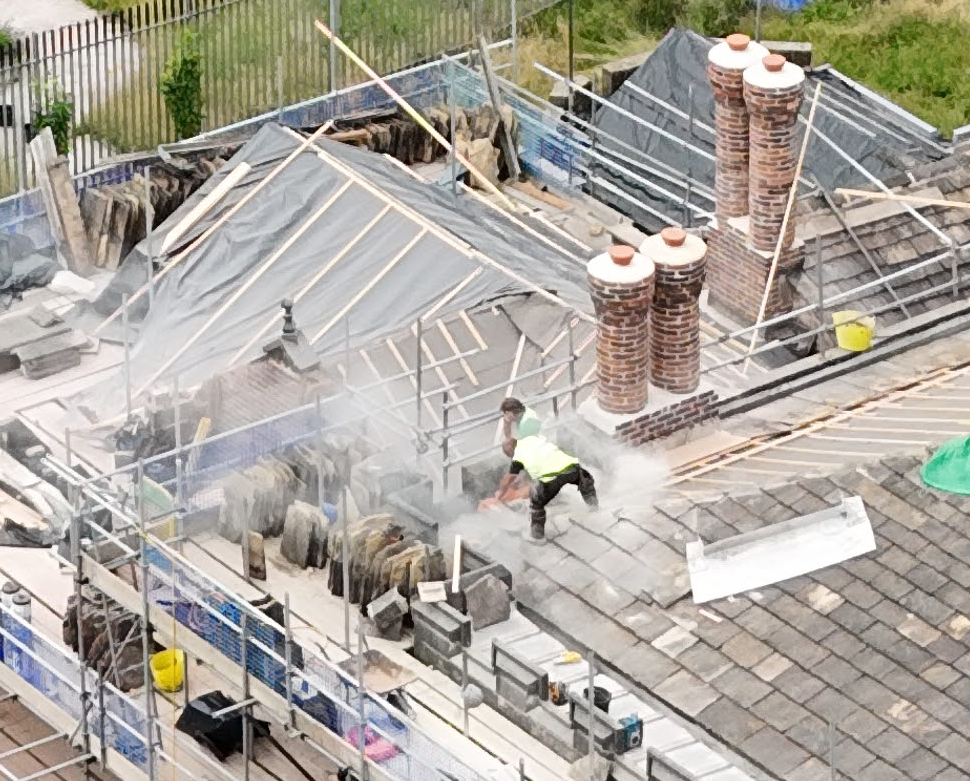 Maysand employees working on the roof without Hard Hats or Protective Glasses, one employee shielding his face with his hand | 📷Hopwood Radio