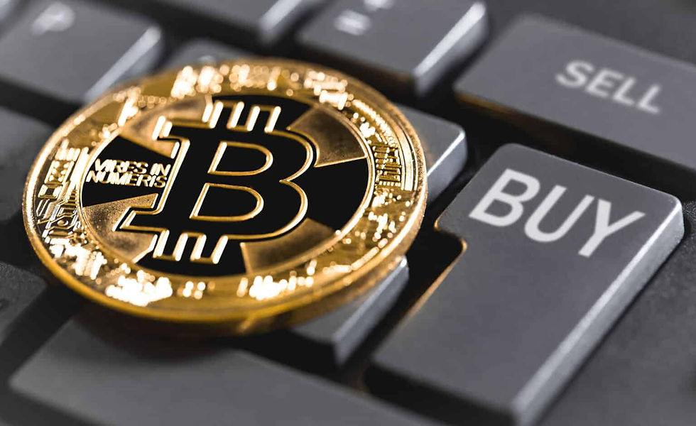 A bitcoin sitting on a keyboard with a key marked "BUY".