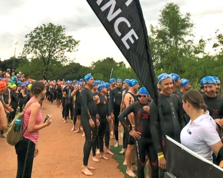 Triathletes waiting to get into swim area looking nervous at a triathlon race