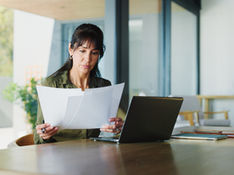 Person reviewing documents at home while planning treatment abroad