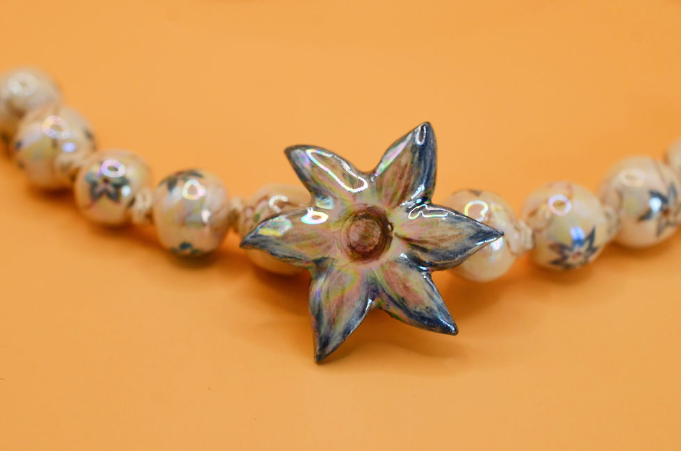 Miniature : Close-up of hand-painted ceramic flower necklace detail