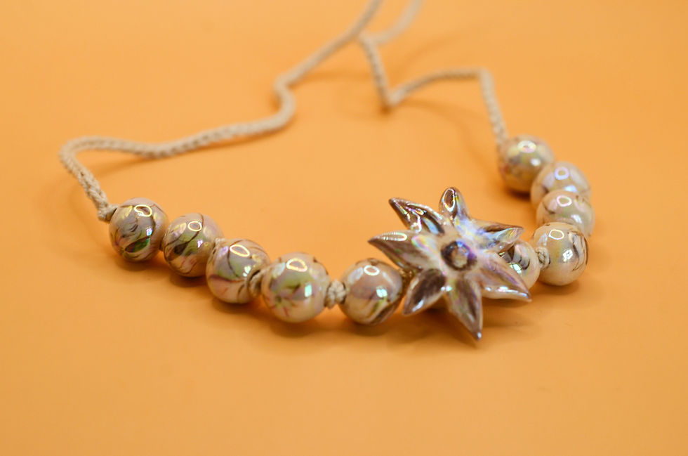 Miniature : Close-up of hand-painted ceramic flower necklace detail