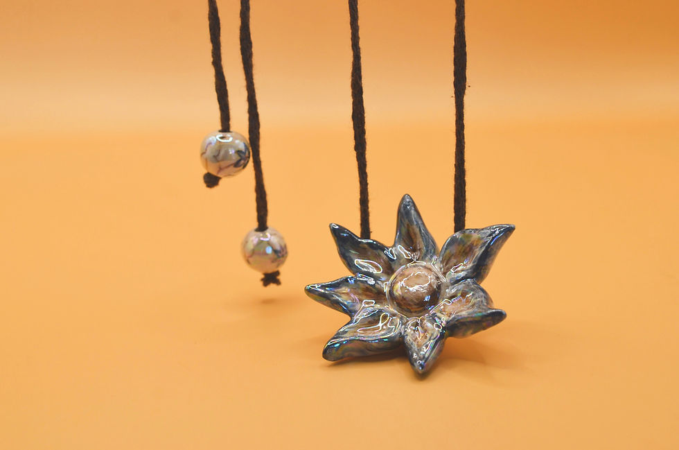 Thumbnail: Close-up of hand-painted blue ceramic flower pendant