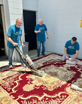 Volunteers cleaning a carpet