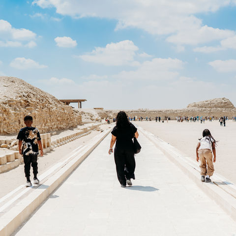 Pyramid & Structures:
• Step Pyramid of Djoser in Saqqara, Egypt.
• The Step Pyramid commands a wide view as it rises over the desert.
• The Step Pyramid stands as an ancient stone structure at the Saqqara archaeological site.
• Entrance to tombs at Saqqara’s necropolis.
• Saqqara pyramid complex under a clear sky.

Tombs & Carvings:
• A Saqqara tomb contains hieroglyphic carvings.
• The wall relief depicts ancient scenes at Saqqara.
• An ancient stone corridor can be found within a burial chamber at Saqqara.
• The Mastaba tombs feature intricate carvings.
• Saqqara is home to preserved artwork from ancient Egypt.

Landscape & Experience:
• A visitor is walking toward the Step Pyramid in Saqqara.
• Desert landscape surrounding Saqqara ruins.
• A family is exploring the Saqqara archaeological area.
	•	Scenic view of Saqqara’s historic structures.
• Photo of the Saqqara complex with a blue sky backdrop.