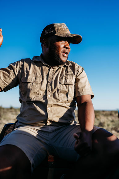• Family on safari vehicle at Tau Game Lodge in Madikwe.
• Guide Silas is leading a game drive in the Madikwe Game Reserve.
• Wildlife sighting during safari at Madikwe, South Africa.
• Elephants gathering near the waterhole at Tau Game Lodge.
• Sunset view over Madikwe Game Reserve.
• Tau Game Lodge's exterior overlooks the landscape.
• A safari vehicle is driving through 76,000 acres of Madikwe terrain.
• Close-up of animals spotted during our safari.
• The family is enjoying a VIP safari experience in South Africa.
• The Madikwe landscape was captured during the sunrise game drive.