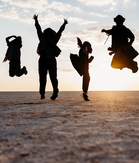 Silhouette of family jumping in the Salt Pans of Botswana