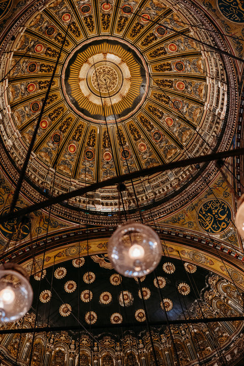 Intricate ceiling architecture with ornate details and hanging lights, Egypt.