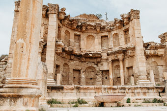 Architecture & Ruins:
• The Roman ruins of Jerash are adorned with stone columns and arches.
• Hadrian’s Arch at the entrance of Jerash.
• Oval Plaza surrounded by columns in Jerash, Jordan.
• Ancient Roman street with stone pavement in Jerash.
• Preserved Roman columns lining the streets of Jerash.
Theaters & Public Spaces:
• South Theater in the ancient city of Jerash.
• Stone seating inside a Roman theater in Jerash.
• Open courtyard and ruins at the Jerash archaeological site.
• Temple ruins with columns standing in Jerash.
• Wide view of Jerash’s ancient city layout.
Experience & Landscape:
• Visitors walking through the Roman ruins of Jerash.
• Families are exploring the historic streets of Jerash.
• Mountain backdrop surrounding the Jerash ruins.
• The sunlit ruins accentuate the grandeur of ancient Jerash.
• Panoramic view of the Jerash archaeological site.