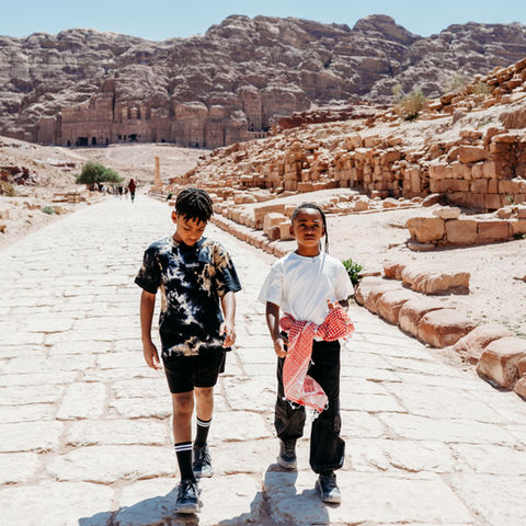 • Entrance to Petra through the Siq canyon in Jordan.
• Narrow sandstone walls of the Siq leading to Petra.
• First view of the Treasury at Petra.
• The Treasury monument carved into rock at Petra.
• Visitors standing in front of the Treasury in Petra.
• Long walking path inside the Petra archaeological site.
• Steps leading up to the Monastery in Petra.
• Children riding donkeys during the climb in Petra.
• Wide view of Petra’s rock formations and trails.
• The Monastery monument at the top of Petra.
• Family exploring Petra’s ancient pathways.
• Scenic overlook from the rear of Petra.
• Stone steps and cliffs along the Petra ascent route.
• Visitors resting during the climb to Petra’s Monastery.
• Expansive desert landscape surrounding Petra.