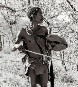 Bush Walk & Survival Skills:
• A San guide leading a bush walk in the Kalahari Desert.
• San tracker demonstrating hunting techniques.
• San woman showing traditional plant medicine.
• A San man explaining how to use natural materials for healing.
• A San guide pointing out animal tracks in the sand.
Cultural Interaction:
• San people welcoming visitors with hugs.
• Family interacting with San community members.
• A San group teaching a traditional game in the Kalahari.
• Visitors learning cultural traditions from the San people.
• San community demonstrating teamwork through a traditional game.
Portrait & Scenery:
• Portrait of a San elder in the Kalahari Desert.
• Traditional San clothing and ornaments.
• San children laughing and playing outdoors.
• Scenic Kalahari Desert view during the bush walk.
• Group photo with the San people in the Kalahari.