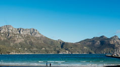 Two people on a beach with mountains and sea in South Africa