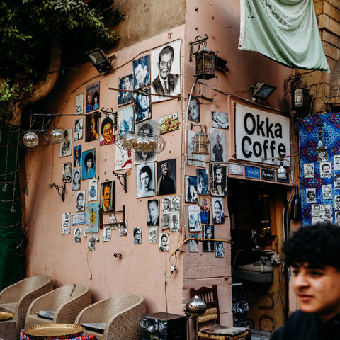 Exterior of Okka Coffee shop, multiple posters, and a person in the corner