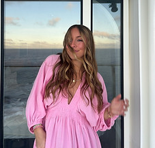 Mady Vivian standing on balcony with wind blowing her hair