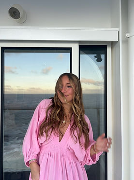 Mady Vivian standing on balcony with wind blowing her hair