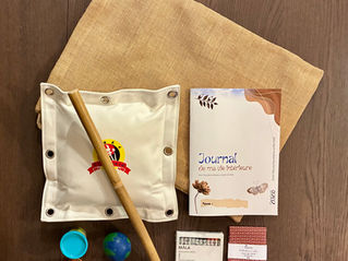 Trousse thérapeutique MIGS ouverte contenant le Journal de ma vie intérieure, crayons de couleur, bâton de rotin et pochette en tissu, outils utilisés en séance