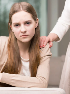 Adolescente le regard triste avec une main posée sur son épaule, illustrant la souffrance silencieuse des ados et le besoin d'écoute