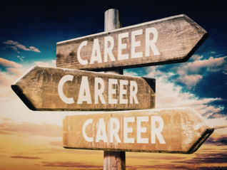 Panneaux en bois indiquant "Career" dans différentes directions, illustrant le carrefour de la reconversion professionnelle