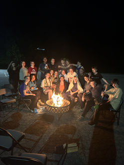 Students gathered around a bonfire at night