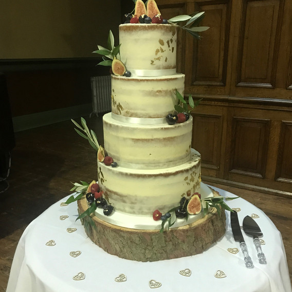 Four tier semi naked cake with gold leaf and fresh fruit