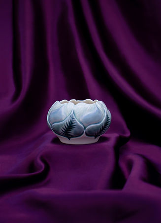 Handmade porcelain ceramic bowl product photography on luxurious purple satin background.