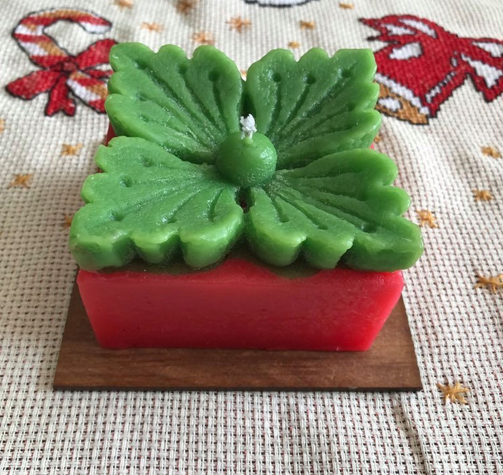 Vela quadrada de duas cores com a flor de natal.  Acompanha base de madeira.